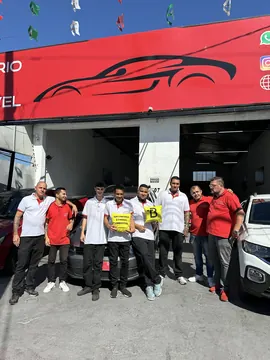 Equipe do Escritório do Automóvel na frente da loja, com as almofadas do escritório