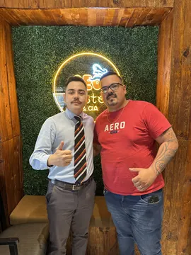 Dr. Thiago com o sócio do Seo Pastel, em frente ao letreiro neon