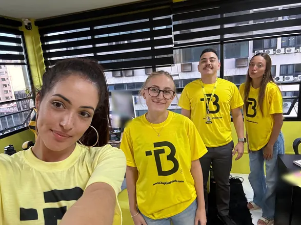 Selfie da equipe com as camisetas amarelas do escritório