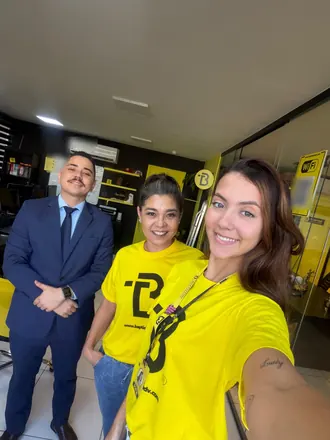 Selfie de duas integrantes da equipe com o Dr. Thiago no escritório