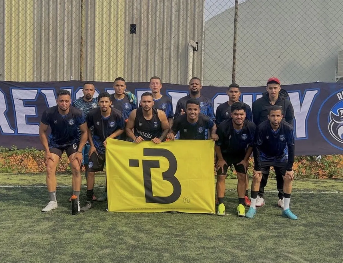 Time de futebol 7 Revoada City posando com a bandeira do escritório